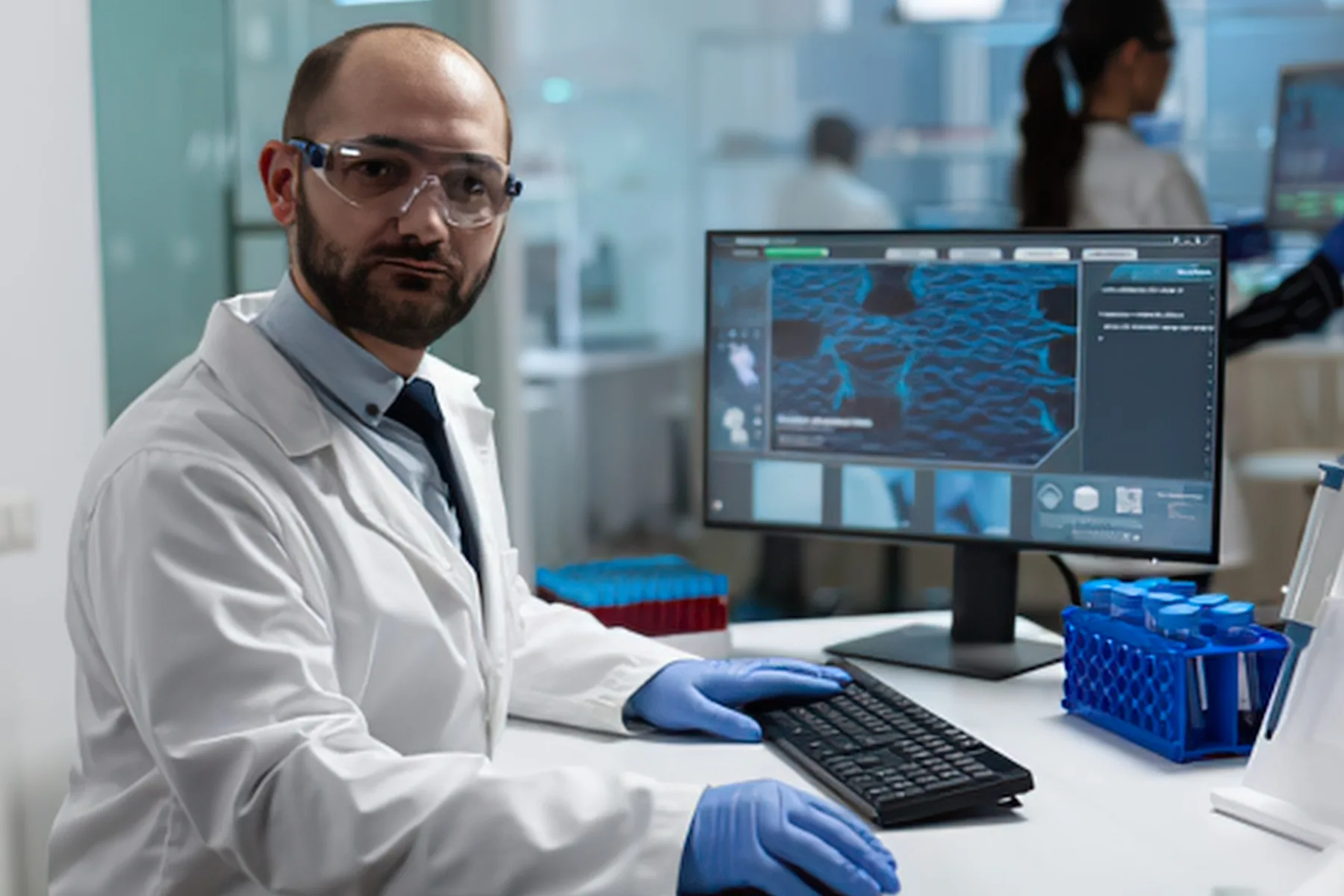 Healthcare researcher at a computer reviewing compliance data